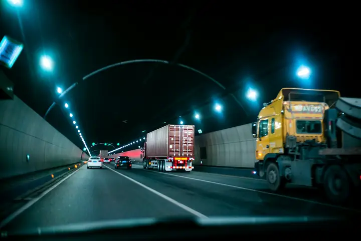 Camions dans un tunnel éclairé, de nuit
